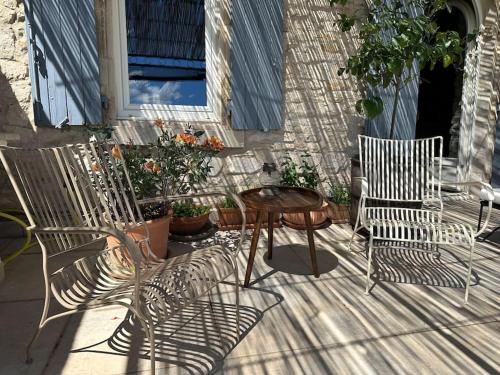 two chairs and a table on a patio at Jolie maison atypique in Vézénobres