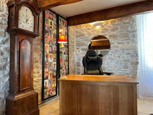 a large wooden clock in a room with a mirror at Jolie maison atypique in Vézénobres