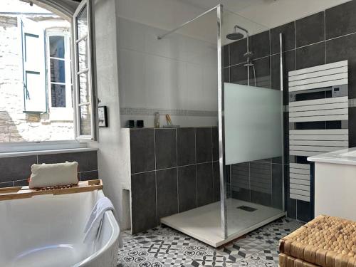 a bathroom with a shower and a bath tub at Jolie maison atypique in Vézénobres