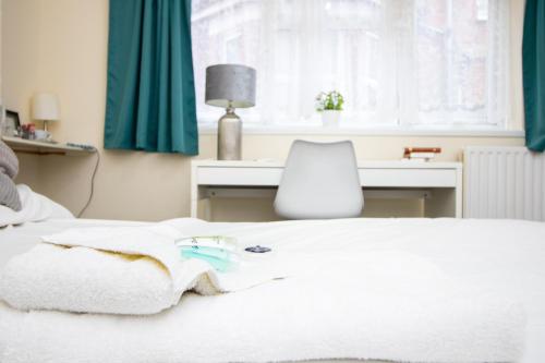 a bedroom with a bed with a desk and a chair at Pebbles guest house room 2 in Southampton