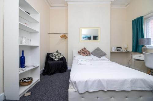 a white bedroom with a bed and a desk at Pebbles guest house room 2 in Southampton