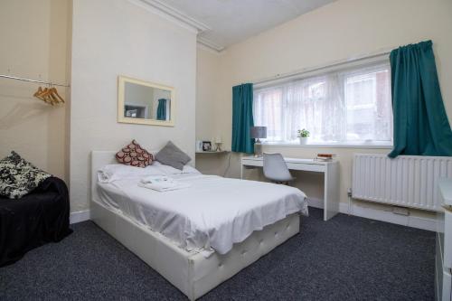 a bedroom with a bed and a desk and a window at Pebbles guest house room 2 in Southampton