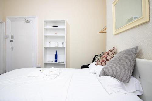 a bedroom with a white bed with white sheets and pillows at Pebbles guest house room 2 in Southampton