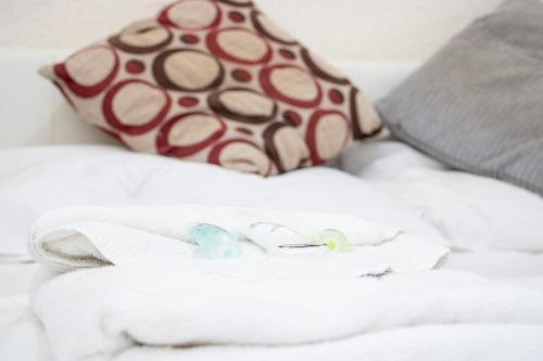 a pile of towels on a bed with a pillow at Pebbles guest house room 2 in Southampton