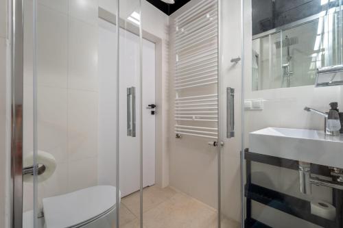 a white bathroom with a sink and a shower at Apartamenty Książka do Poduszki - 250 metrów do Bulwarów Wiślanych - Dream Apart in Ustroń