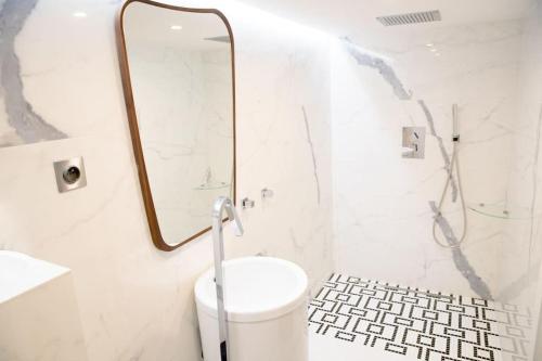 une salle de bain avec des toilettes blanches et un miroir dans l'établissement Monaco Beausoleil I Luxueux Duplex 1BR vue Mer, à Beausoleil