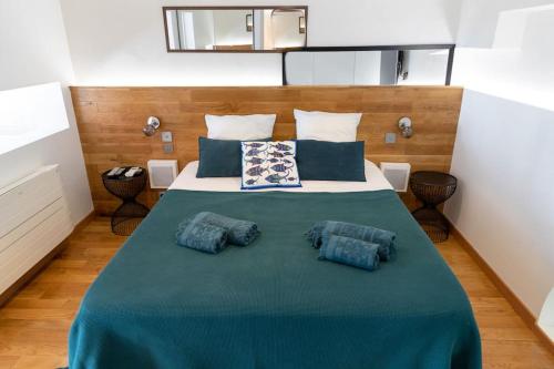 une chambre avec un grand lit avec des oreillers bleus dans l'établissement Monaco Beausoleil I Luxueux Duplex 1BR vue Mer, à Beausoleil