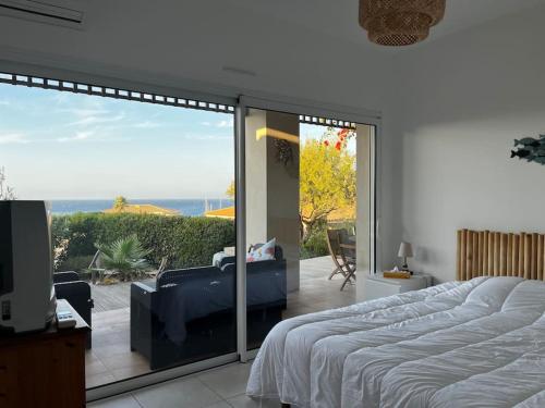 une chambre avec un lit et un balcon avec vue dans l'établissement Appartement avec jardin vue mer, à Lumio