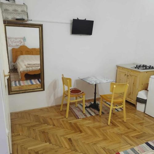 a room with a table and two chairs and a mirror at Zempléni Szálláshely in Fony