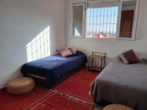 a bedroom with two beds and a window at Découvrez ce havre de paix in Imi Ouaddar