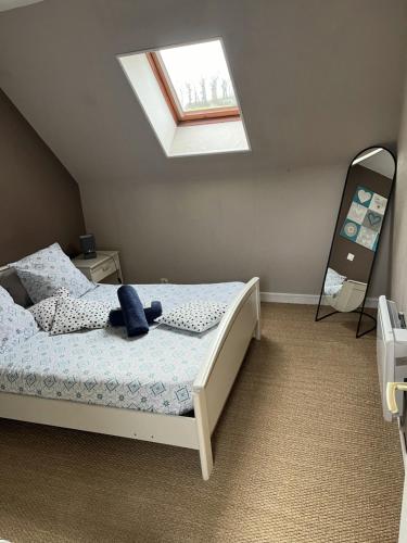 a bedroom with a bed with a teddy bear on it at Chambres d'hôte du Domaine de la Reine Blanche in Criquetot-sur-Longueville