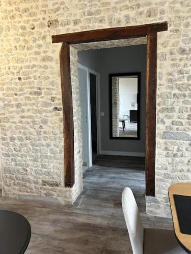 Cette chambre est dotée d'un mur en briques et d'un miroir. dans l'établissement Appartement avec cours extérieur, à Trévières