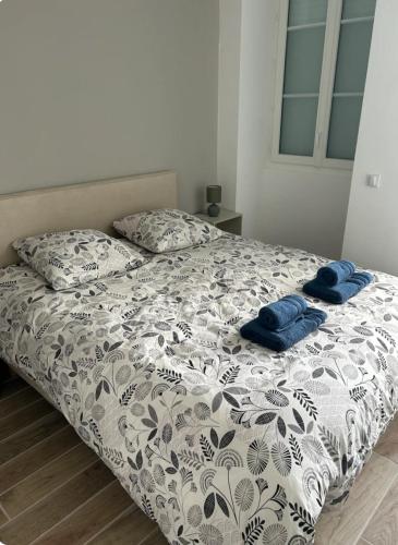 un lit avec deux serviettes bleues dessus dans l'établissement Appartement avec cours extérieur, à Trévières