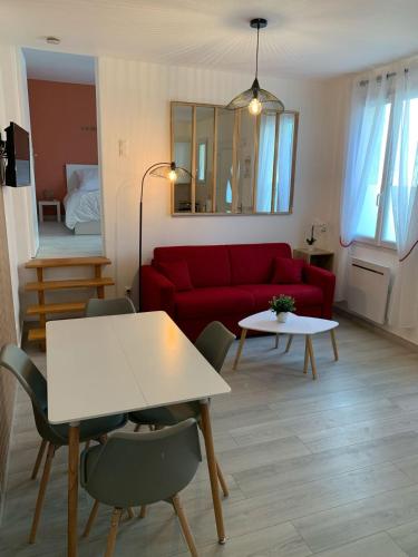 un salon avec un canapé rouge et une table dans l'établissement Appartement proche Aéroport Orly - Ligne 14, à Orly