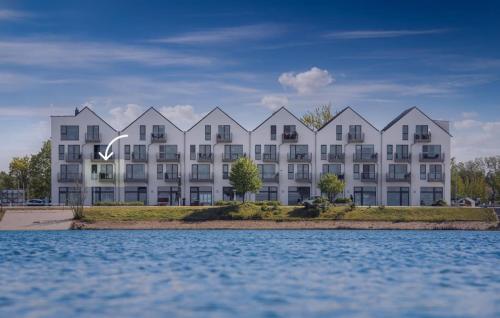 a large white building next to the water at Segler Nest in Olpenitz