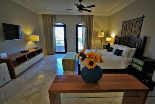 a bedroom with a bed and a vase of flowers on a table at Propiedad Fishing Lodge in Punta Cana