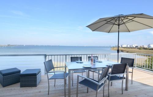 a table and chairs on a deck with an umbrella at Wilbur in Olpenitz
