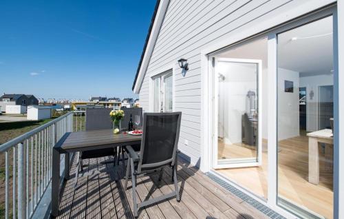 a deck with a table and chairs on a balcony at Windrose in Olpenitz