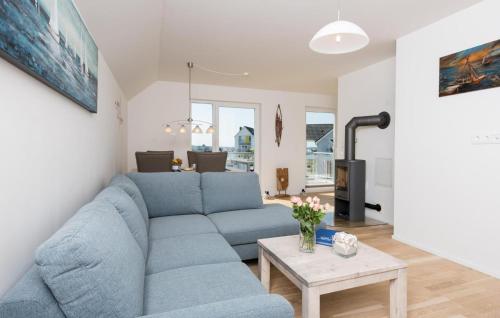 a living room with a blue couch and a table at Windrose in Olpenitz