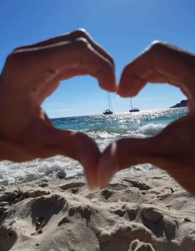 a pair of hands forming a heart on the beach at Apartments Babic in Podstrana