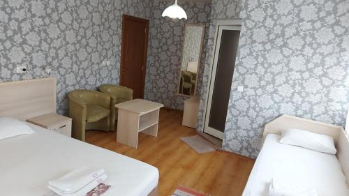 a small room with two beds and a mirror at Family Hotel Emaly 1 in Bankya