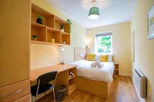a bedroom with a bed and a desk and a window at 17 - Spacious 2 Bed Apt with Parking in Galway