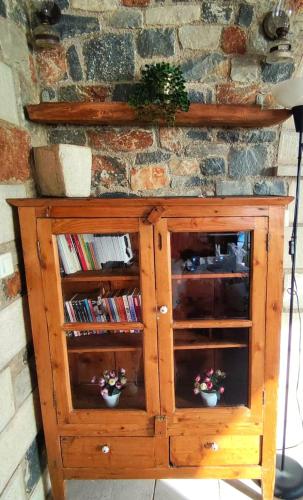 a wooden cabinet with two shelves and a stone wall at Refoulo Tower in Poliána