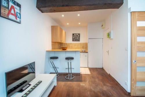 une cuisine avec un comptoir et des tabourets dans une pièce dans l'établissement Studio spacieux dans le beau quartier du Marais, à Paris