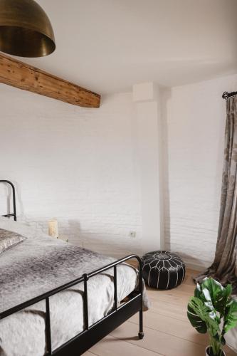 a bedroom with a bed and a white wall at The Millhouse in Sint-Niklaas