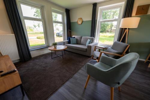 a living room with two chairs and a table at Waterdorp Burdaard in Burdaard