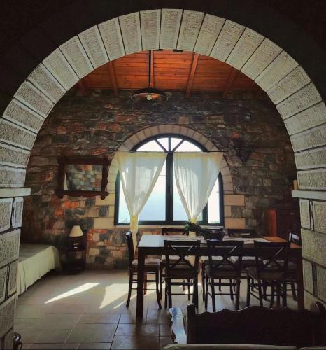 a dining room with a table and chairs in a brick wall at Refoulo Tower in Poliána