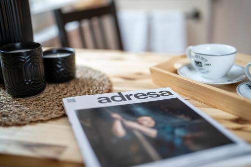 a tablet on a wooden table with cups and a magazine at Vila Heide in Česká Kamenice