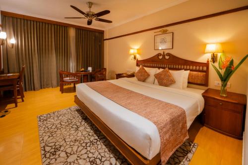 a hotel room with a large bed and a table at The Raviz Kadavu, Kozhikode in Kozhikode