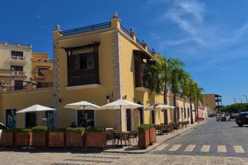 a building with tables and umbrellas on a street at Propiedad Fishing Lodge in Punta Cana