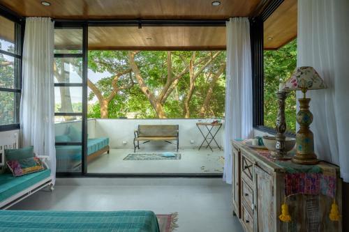 a living room with a large window and a couch at SaffronStays Jade in Kārli