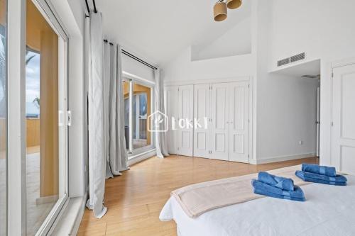 Un dormitorio con una cama con dos almohadas azules encima. en Penthouse Paradise - Sotogrande, en Sotogrande
