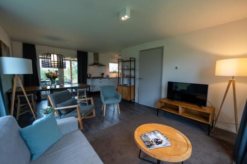 a living room with a couch and a table at Waterdorp Burdaard in Burdaard