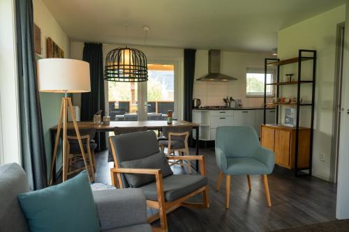 a kitchen and living room with a table and chairs at Waterdorp Burdaard in Burdaard