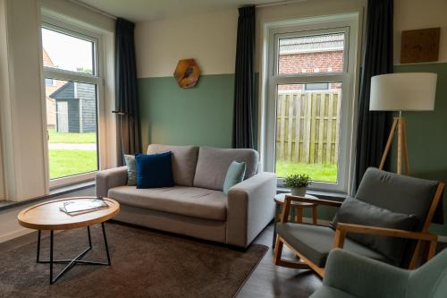 a living room with a couch and two chairs at Waterdorp Burdaard in Burdaard