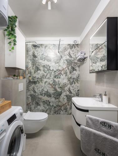 a bathroom with a sink and a washing machine at Star Apartments in Tar