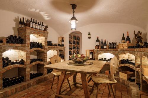 a dining room with a table and lots of wine bottles at Hotel Pienzenau Am Schlosspark in Merano