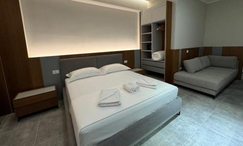 a bedroom with a large bed and a couch at Anchor Luxury Rooms in Vlorë