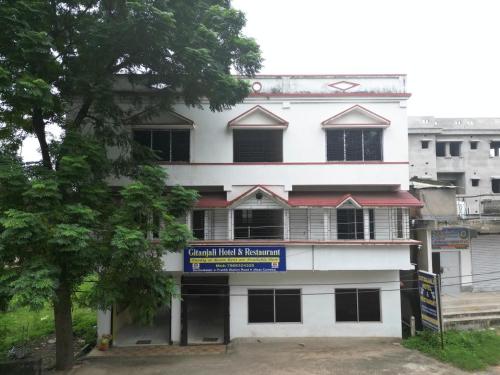桑蒂尼盖登Gitanjali Hotel & Restaurant的一座挂着招牌的白色建筑