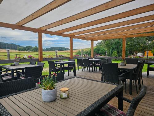 un patio con tavoli e sedie su un ponte di legno di Pension Achterland a Mellenthin