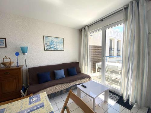 un salon avec un canapé et une grande fenêtre dans l'établissement Appartement mansardé avec terrasse à 100m de la Plage St-Guirec, Ploumanac'h - FR-1-368-161, à Perros-Guirec