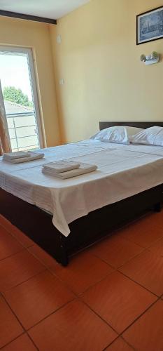 a large bed with towels on it in a room at Vilele Brise de Mer in 2 Mai