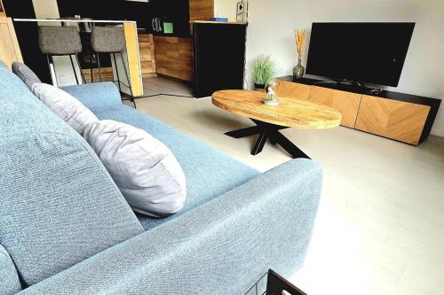 a living room with a blue couch and a coffee table at F2 en centre ville proche gare in Beauvais
