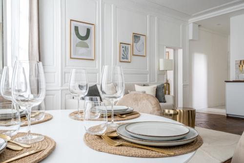 - une table à manger avec des verres à vin et des assiettes dans l'établissement Le Versaillais - Proche Château de Versailles et 15 min RER Paris, à Versailles