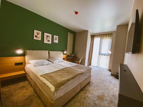 a bedroom with a large bed with a green wall at B1 Downtown Hotel in Sofia