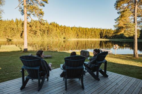a group of people sitting in chairs on a deck near a lake at Gråbogården event and conference center in Gråbo